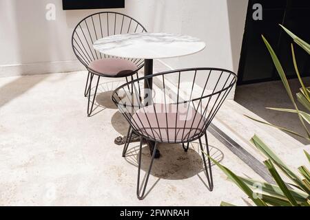 Stilvolle, moderne Stühle und Steintisch auf der geräumigen Terrasse Stockfoto