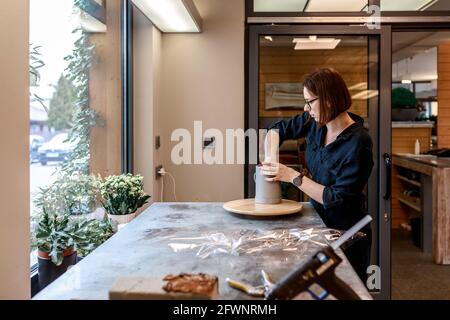 Frau Blumenstrauß Blumenstrauß in der Werkstatt. Geschenkkonzept, Schulung, Meisterkurs zum Sammeln von Blumensträußen in einer Schachtel. Stockfoto