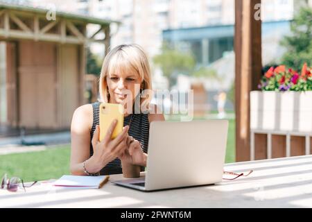 Erwachsene Frau in Brille mit Laptop Stockfoto