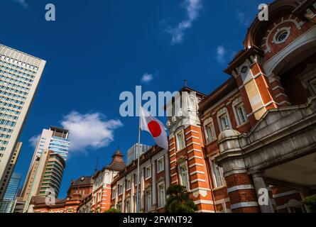 Tokyo Station wunderschöne rote Backsteinfassade mit japanischer Nationalflagge Stockfoto