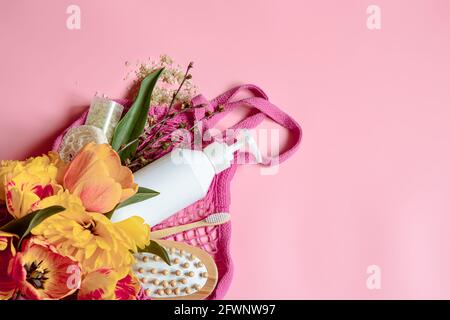 Flat Lay Spa Komposition mit Blumen und Badaccessoires in einem Saitenbeutel. Stockfoto