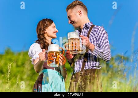 Deutsches Paar in Tracht mit Bier und Brezel Stockfoto