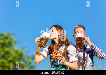 Deutsches Paar in Tracht mit Bier und Brezel Stockfoto