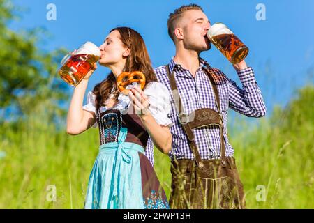 Deutsches Paar in Tracht mit Bier und Brezel Stockfoto