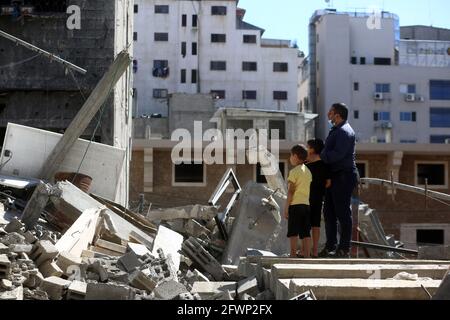 Gaza-Stadt. Mai 2021. Palästinenser stehen auf den Trümmern ihrer Häuser, die während eines israelischen Luftanschlags in Gaza-Stadt am 23. Mai 2021 zerstört wurden. Kredit: Rizek Abdeljawad/Xinhua/Alamy Live Nachrichten Stockfoto