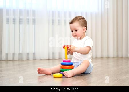 Ein kleines Kind mit blauen Augen spielt im Spielzimmer. Stockfoto