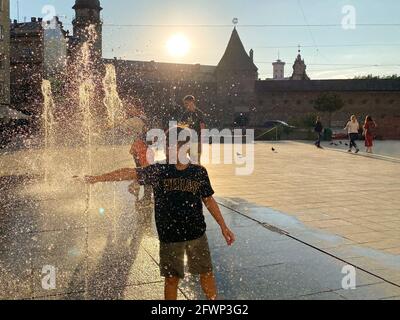 Lviv, Ukraine - 2. September 2020 : Kinder spielen und entspannen sich in der Nähe des Fußgängerbrunnens auf dem Mytna-Platz in Lviv bei Sonnenuntergang. Selektiver Fokus Stockfoto