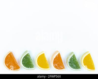 Bunte Marmelade Zitrusscheiben in Zucker auf weißem Hintergrund mit Kopierraum. Stockfoto