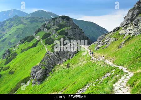 Der Weg vom Berg Kasprov führt entlang der polnisch-slowakischen Grenze. Einige Wanderer auf dem Weg. Hohe Tatra, Polen. Stockfoto