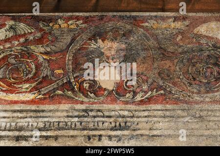 Fresko aus Satyr-Maske aus der Renaissance zwischen Füllhorn an der Wand des Magno-Palazzo oder des Großen Palastes, ehemalige Residenz der Bischöfe von Trient in Trient, Trentino-Südtirol, Italien. Der Palast wurde 1528 im Festungskomplex Castello del Buonconsiglio von Kardinal Bernardo Clesio oder Cles, dem Kanzler des Heiligen Römischen Reiches und Fürstbischof von 1514 bis 39, gegründet. Das dekorative Schema verbindet mythologische Motive mit historischen Szenen und kaiserlichen Motiven wie den Waffen und Porträts habsburgischer Kaiser. Stockfoto