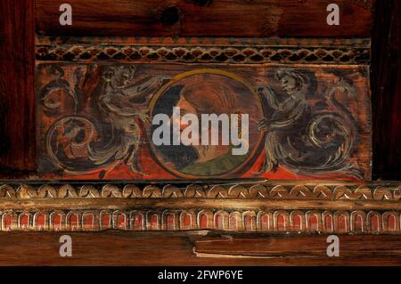 Frau mit langer Nase, die in einem kreisförmigen Porträtmedaillon auf einem Holzpaneel der Renaissance-Decke im Palazzo Magno oder im Großen Palast, der ehemaligen Residenz der Bischöfe von Trient in Trento, Trentino-Südtirol, Italien, profiliert ist. Der Palast wurde 1528 im Festungskomplex Castello del Buonconsiglio von Kardinal Bernardo Clesio oder Cles, dem Kanzler des Heiligen Römischen Reiches und Fürstbischof von 1514 bis 39, gegründet. Das dekorative Schema verbindet mythologische Motive mit historischen Szenen und kaiserlichen Motiven wie den Waffen und Porträts habsburgischer Kaiser. Stockfoto