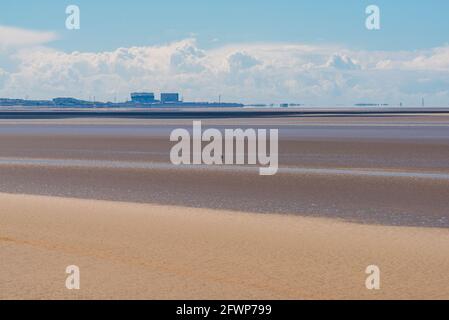 Blick von Far Arnside über die Morecambe Bay in Richtung Heysham-Kraftwerk, Lancashire, Großbritannien mit einem Spaziergänger auf dem Sand Stockfoto