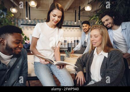 Gruppe von jungen Geschäftsleuten, die während des Treffens in Dokumente diskutieren Büro Stockfoto