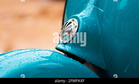 Vespa Scooter Vorderansicht, geparkt in einer schlammigen Straße an einem regnerischen Tag. Sky Blue Vintage Classic Motorrad. Stockfoto