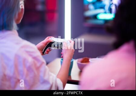 Nahaufnahme der Hände einer Spielerin, die mit dem DualSense PS5-Joystick Videospiele auf der PlayStation 5-Spielkonsole spielt. Moskau - November 28 2020 Stockfoto