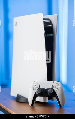 Die neue Sony Spielekonsole PlayStation 5 und der DualSense Controller in einem pinken Neonlicht. Moskau - November 28 2020 Stockfoto