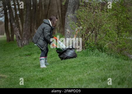 Mädchen Freiwillige sammelt Müll im Wald, kümmert sich um die Umwelt. Stockfoto