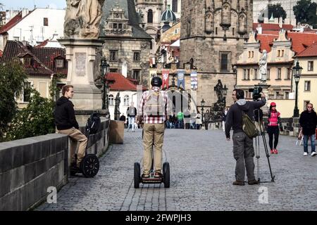 Bild von Touristen, jungen Männern, Reiten Segways im Stadtzentrum von Prag, Tschechische republik, auf der Karlsbrücke, auch bekannt als Karluv Most. Stockfoto