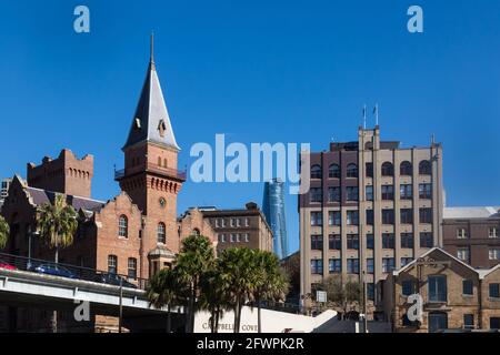 Blick auf die Campbells Cove, die im Gegensatz zur modernen Skyline der Stadt unter Denkmalschutz stehende Gebäude und Lagerhäuser aus der Zeit vor der Föderation zeigt. Stockfoto