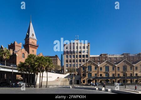 Blick auf die Campbells Cove, die im Gegensatz zur modernen Skyline der Stadt unter Denkmalschutz stehende Gebäude und Lagerhäuser aus der Zeit vor der Föderation zeigt. Stockfoto