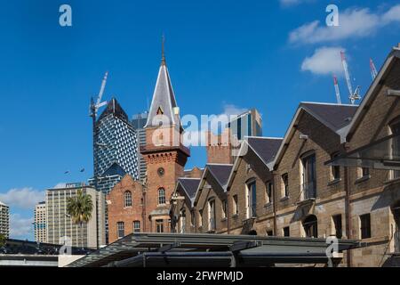 Blick auf die Campbells Cove, die im Gegensatz zur modernen Skyline der Stadt unter Denkmalschutz stehende Gebäude und Lagerhäuser aus der Zeit vor der Föderation zeigt. Stockfoto