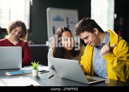 Down-Syndrom-Mann, der die Bildungsklasse im Gemeindezentrum besucht, einschließlich der Behinderten. Stockfoto