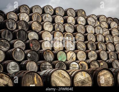 Ein großer Haufen Whiskyfässer, die übereinander gestapelt sind. Stockfoto