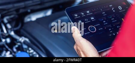Kfz-Service-Mechaniker mit digitalen Tablet mit Diagnose-Software, um den Zustand des Motors zu überprüfen. Fahrzeuginspektion. Banner Stockfoto