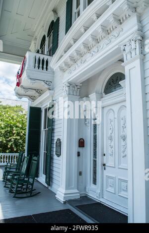 Eintritt zum Bellamy Mansion im historischen Stadtzentrum von Wilmington, North Carolina. Schaukelstühle auf der weitläufigen Veranda dieses Vorkriegsbesitzes. Stockfoto