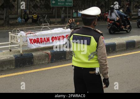 Madiun Resort Polizeipersonal, das den Verkehrsfluss vor dem Sarg regelt, der das Theater des Opfers aufgrund der Exposition gegenüber dem Corona-Virus oder Covid-19 in Madiun Regency ist. Gemeinsame Mitarbeiter führen Aktivitäten im Rahmen einer Kampagne zur Verhinderung des Corona-Virus oder Covid-19 durch, indem sie das 5M-Gesundheitsprotokoll sozialisieren, nämlich Hände mit fließendem Wasser waschen, Masken tragen, Distanz bewahren, Mobilität einschränken und sich von Menschenmengen fernhalten (Foto: Ajun Ally/Pacific Press/Sipa USA) Stockfoto