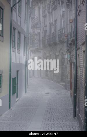 Alte neblige schmale Straße von Porto bei Sonnenaufgang, Portugal. Stockfoto