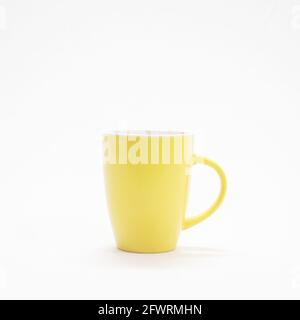 Schlichte und einfache gelbe Kaffeetasse in einem weißen isoliert Hintergrund Stockfoto