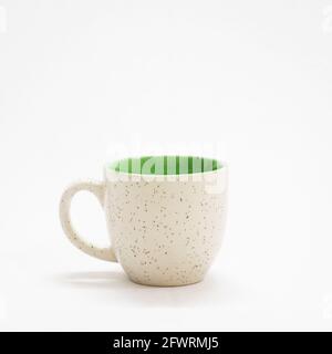 Leere, einfache Kaffeetasse mit Punktmuster auf weißem Hintergrund Stockfoto