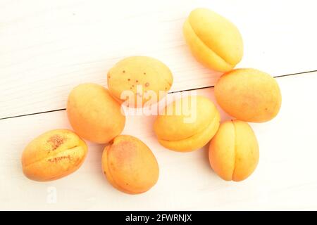 Mehrere Bio-gelbe Ananas-Aprikosen, Nahaufnahme, auf einem Holztisch, Draufsicht. Stockfoto