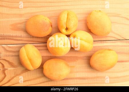 Mehrere Bio-gelbe Ananas-Aprikosen, Nahaufnahme, auf einem Holztisch, Draufsicht. Stockfoto