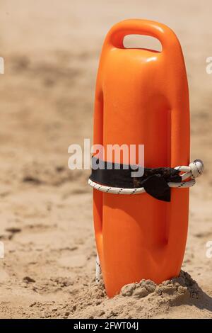 Eine orangefarbene Rettungsboje, in den Sand gekippt, bereit für jede Hilfs- und Rettungsaktion, am Strand von Torrenostra, Provinz Castellon, Valenc Stockfoto