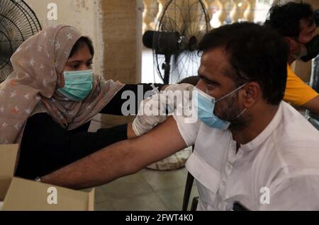 Gesundheitshelfer verabreicht Bürgern während der Impfkampagne gegen das Coronavirus am Montag, den 24. Mai 2021, in der Khaliq Dina Hall in Karachi einen Impfstoff gegen Covid-19 Sinopharm. Stockfoto