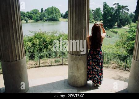 Frau, die die Landschaft vom Tempel der Liebe im Wald von Vincennes, Paris aus betrachtet Stockfoto