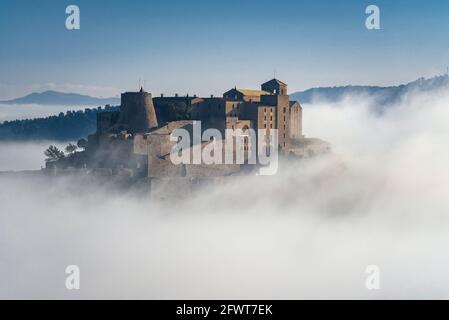 Burg Cardona, die aus dem Morgennebel auftaucht (Barcelona, Katalonien, Spanien) ESP: El castillo de Cardona, emergiendo entre la niebla por la mañana Stockfoto