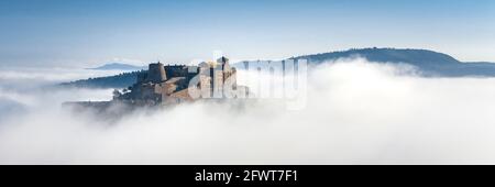 Burg Cardona, die aus dem Morgennebel auftaucht (Barcelona, Katalonien, Spanien) ESP: El castillo de Cardona, emergiendo entre la niebla por la mañana Stockfoto