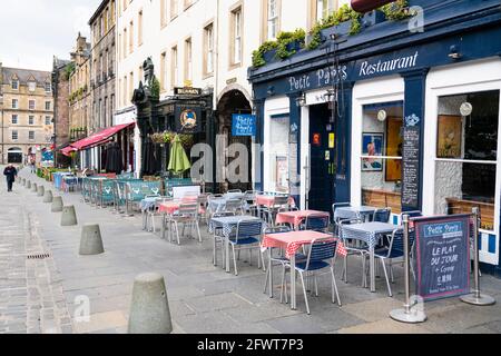 Schottland, Schottland, Großbritannien. 24 Mai 2021. Das für die Saison unangenehme kühle und feuchte Wetter in Edinburgh bedeutete, dass es in den vielen Außenbars, Cafés und Restaurants im Stadtzentrum nur wenige Kunden gab, während in der Hauptstadt nur wenige Touristen unterwegs waren. PIC; Sitzplätze im Freien für Bars und Restaurants liegen zur Mittagszeit auf dem beliebten Grassmarket leer. Iain Masterton/Alamy Live News Stockfoto