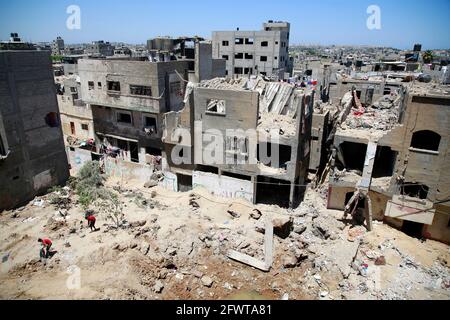 In Beit Hanoun im nördlichen Gazastreifen inspizieren Palästinenser ihre zerstörten Häuser neben Gebäuden, die von israelischen Luftangriffen Anfang des Monats schwer beschädigt wurden.ENDE der vergangenen Woche wurde nach 11 Tagen tödlicher Gewalt zwischen Israel und der Hamas-Bewegung, die den Gazastreifen führt, ein Waffenstillstand erreicht. Beendigung des verheerenden Bombardements Israels auf die überfüllte palästinensische Küstenenklave, bei der nach Angaben des Gesundheitsministeriums von Gaza 248 Palästinenser, darunter 66 Kinder, getötet und mehr als 1,900 Menschen verletzt wurden. Unterdessen Raketen aus Gaza. Stockfoto