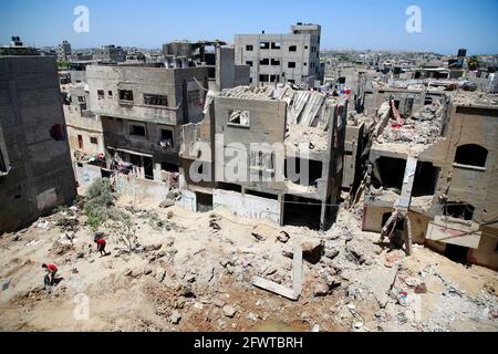 In Beit Hanoun im nördlichen Gazastreifen inspizieren Palästinenser ihre zerstörten Häuser neben Gebäuden, die von israelischen Luftangriffen Anfang des Monats schwer beschädigt wurden.ENDE der vergangenen Woche wurde nach 11 Tagen tödlicher Gewalt zwischen Israel und der Hamas-Bewegung, die den Gazastreifen führt, ein Waffenstillstand erreicht. Beendigung des verheerenden Bombardements Israels auf die überfüllte palästinensische Küstenenklave, bei der nach Angaben des Gesundheitsministeriums von Gaza 248 Palästinenser, darunter 66 Kinder, getötet und mehr als 1,900 Menschen verletzt wurden. Unterdessen Raketen aus Gaza. (Foto von Ahmed Zakot/SOPA Images/Sipa USA) Stockfoto