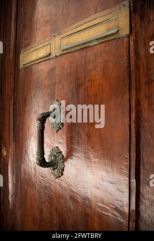 Alte Holztür mit glänzendem Metallgriff in der. Nahaufnahme des Türgriffs. Venedig, Italien Stockfoto