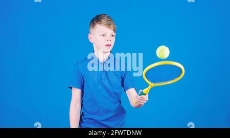 Athlet Kinder Tennisschläger auf blauem Hintergrund. Tennis Sport und Unterhaltung. Junge Kind spielt Tennis. Tennisspielen üben. Kerl mit Schläger genießen Stockfoto