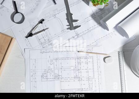 Schreibtisch des Architekten des Entwurfprojekts Skizzen. Arbeitsplatz eines Bauingenieurs, der Baupläne erstellt. Draufsicht. Stockfoto