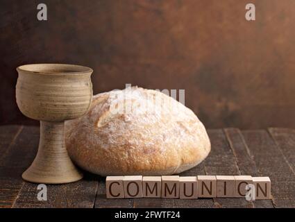 Das Sakrament der Heiligen Kommunion auf einem dunklen Holztisch Stockfoto