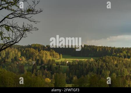 Regenbogen über Bernov Dorf in Sonnenuntergang Abend mit grünen frisch Wiesen Stockfoto