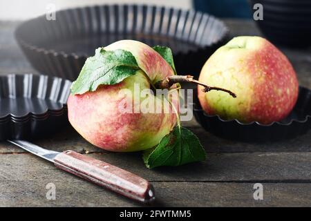 Frischer roter Apfel auf einem hölzernen Küchentisch. Stockfoto