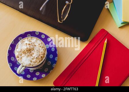 Tisch mit Kaffee, Buch, Bleistift, stickynote, Laptop und Brille Stockfoto